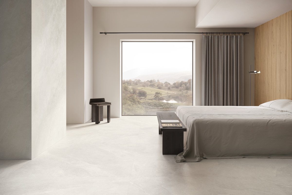 Heller Steinbodenbelag in einem modernen, lichtdurchfluteten Raum mit grossem Panorama-Fenster.