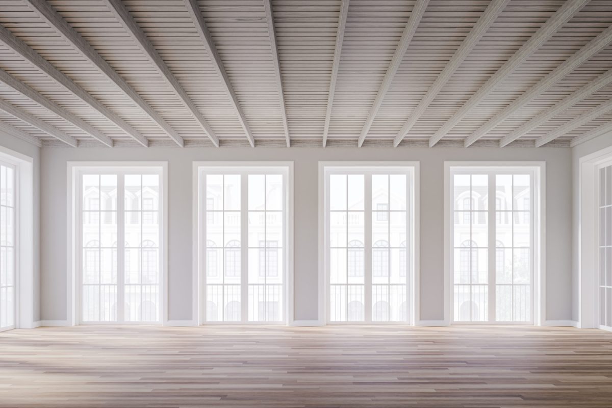 Mehrere grosse Fensterfronten mit weissen Rahmen, die einen hellen Wohnraum mit viel Tageslicht schaffen.